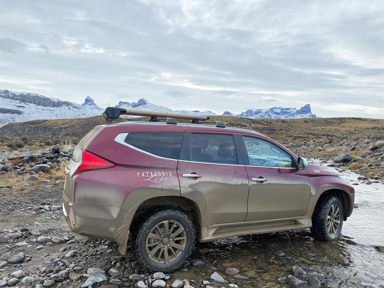 Patagonia Line 4x4 at a river crossing below snow-dusted peaks