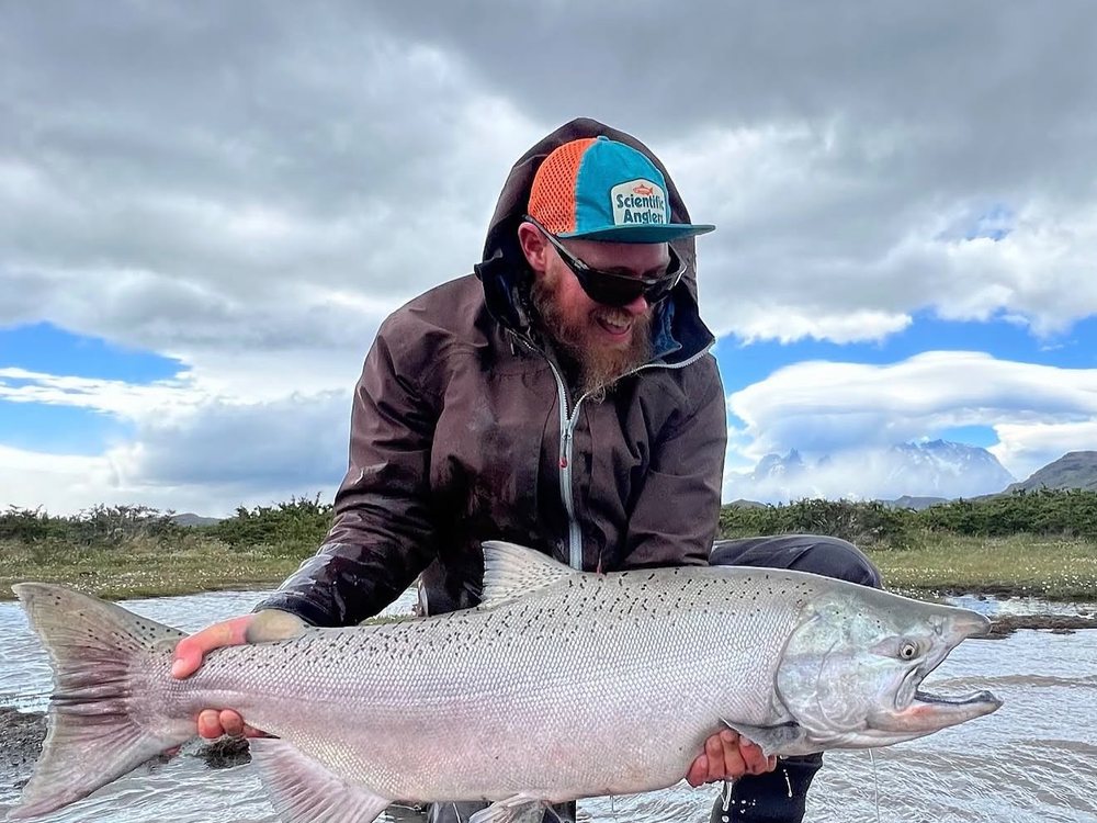 Martín con un salmón rey frente al macizo del Paine